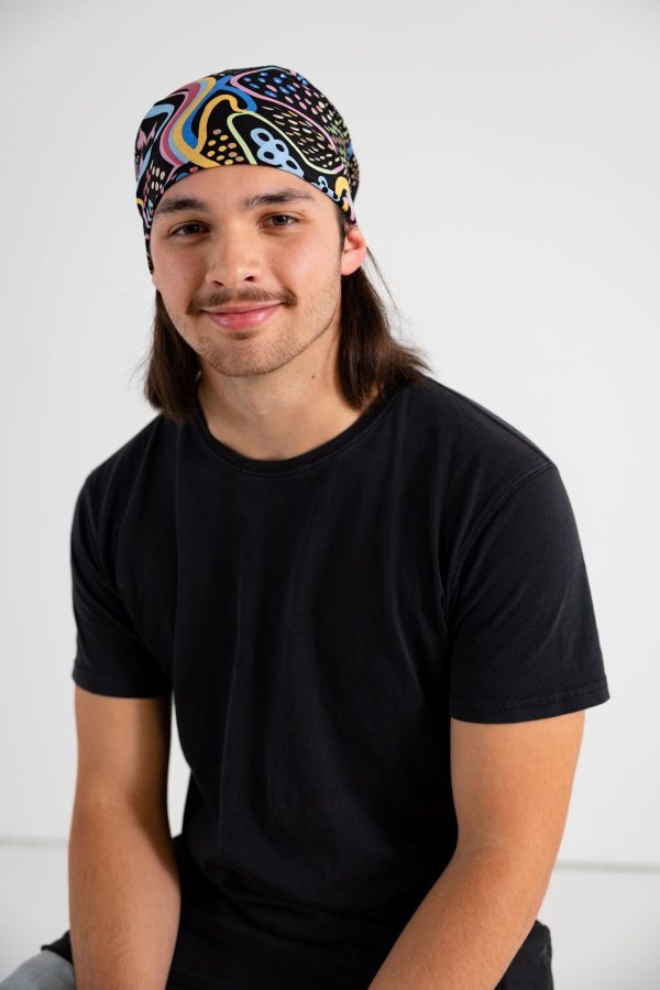 A person wearing a Dreaming Track Nights bandanna on their head