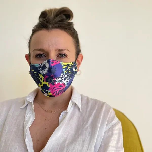 A person wearing a floral face mask