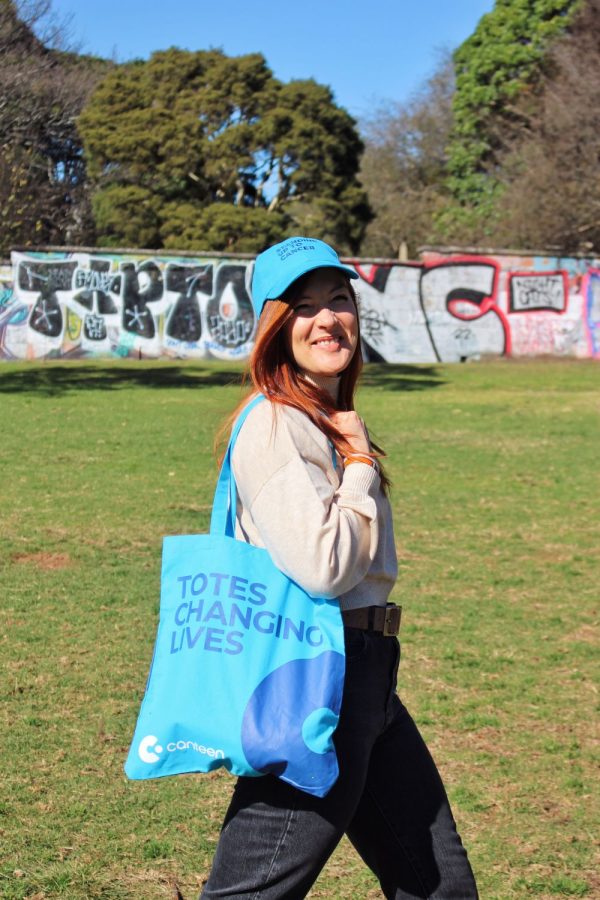 A person wearing a blue tote bag on their right shoulder
