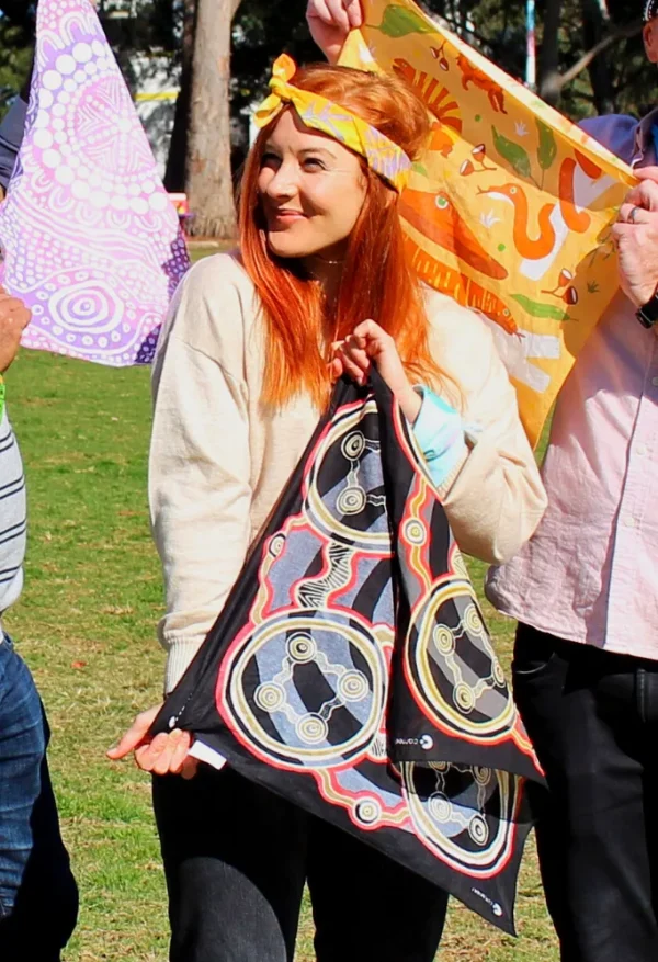A person holding a Saltwater Dreaming bandanna